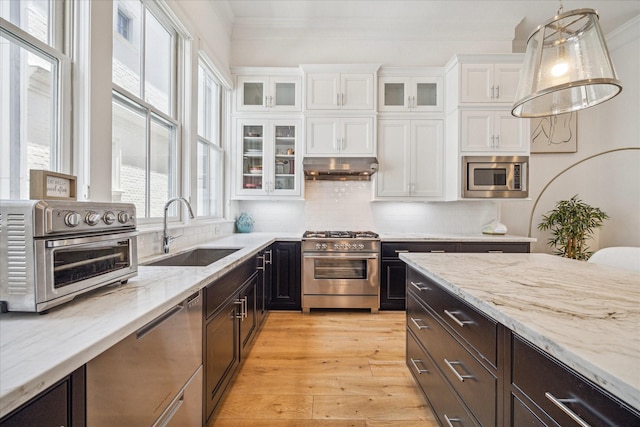 6110 Nicholas Grove Pl, Houston, TX 77055 - kitchen featuring a sink, stainless steel appliances, white cabinets, ornamental molding, and light stone countertops