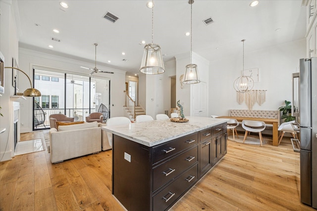 6110 Nicholas Grove Pl, Houston, TX 77055 - kitchen featuring light wood-style flooring, freestanding refrigerator, crown molding, a ceiling fan, and a center island