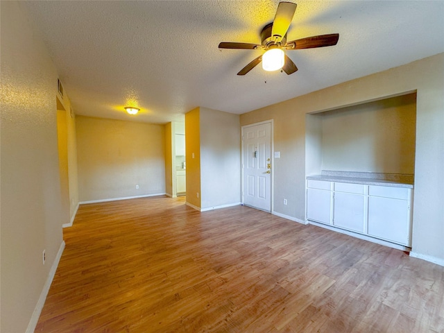 12615 Brookglade Cir Unit 309, Houston, TX 77099 - unfurnished room featuring light wood-type flooring, a ceiling fan, a textured ceiling, and baseboards