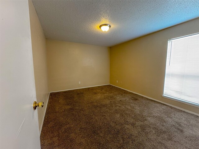 12615 Brookglade Cir Unit 309, Houston, TX 77099 - empty room featuring a textured ceiling, carpet, and baseboards