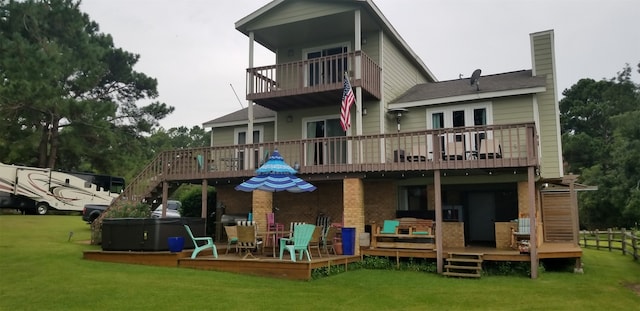 41 Lakeview Shores Dr, Coldspring, TX 77331 - rear view of house with a balcony, a hot tub, a chimney, a lawn, and a deck