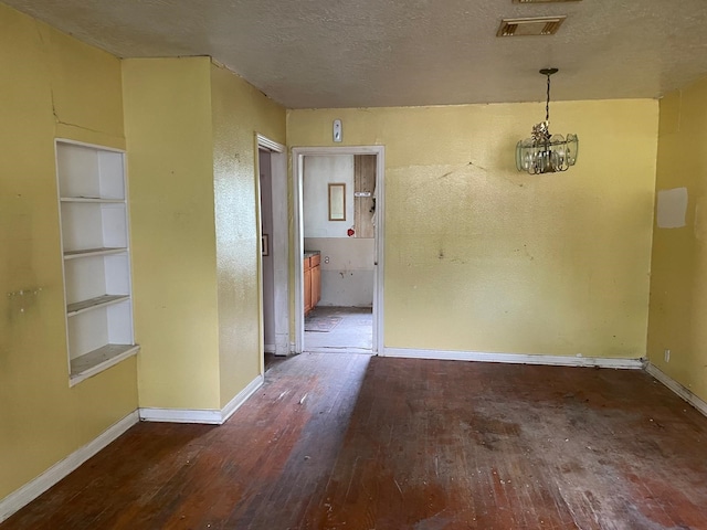 3706 Yosemite St, Houston, TX 77021 - empty room featuring hardwood / wood-style flooring, baseboards, a chandelier, built in shelves, and a textured ceiling