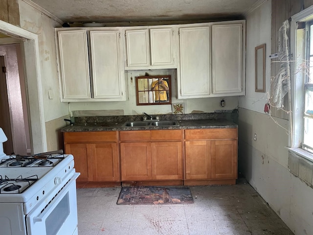 3706 Yosemite St, Houston, TX 77021 - kitchen featuring white gas stove, a sink, dark countertops, brown cabinetry, and crown molding