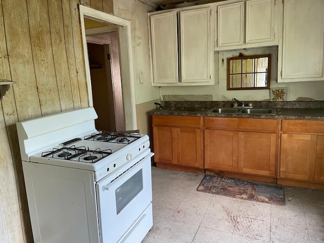 3706 Yosemite St, Houston, TX 77021 - kitchen with white range with gas stovetop, a sink, and dark countertops