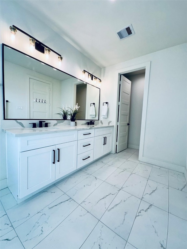210 E 39th St, Houston, TX 77018 - bathroom with marble look tile flooring, double vanity, and baseboards