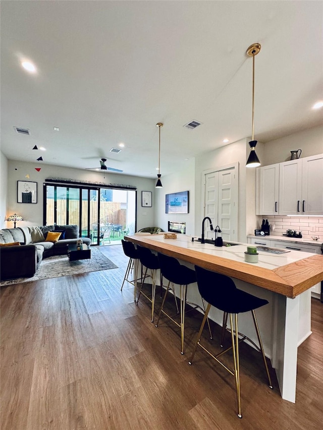210 E 39th St, Houston, TX 77018 - kitchen featuring wooden counters, a sink, dark wood-style floors, white cabinets, and open floor plan