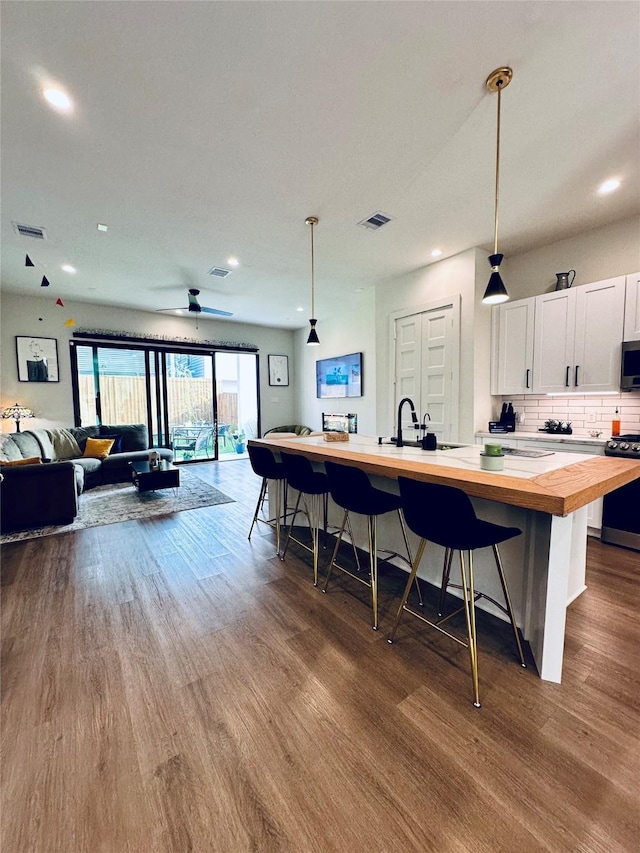 210 E 39th St, Houston, TX 77018 - kitchen with butcher block counters, range, open floor plan, dark wood-style floors, and hanging light fixtures