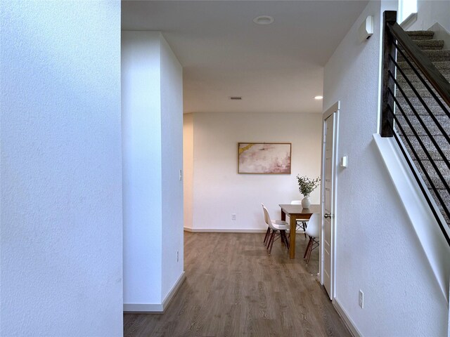 12545 Walmgate Ct, Houston, TX 77047 - hall with wood finished floors, baseboards, a textured wall, and stairway