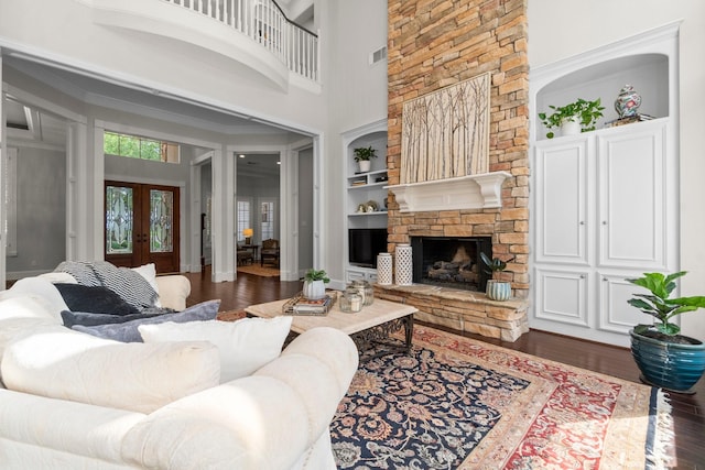 91 N Hunters Crossing Cir, The Woodlands, TX 77381 - living room with french doors, wood finished floors, built in shelves, a fireplace, and a high ceiling