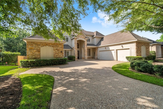 91 N Hunters Crossing Cir, The Woodlands, TX 77381 - traditional-style home with stone siding, a garage, concrete driveway, and stucco siding