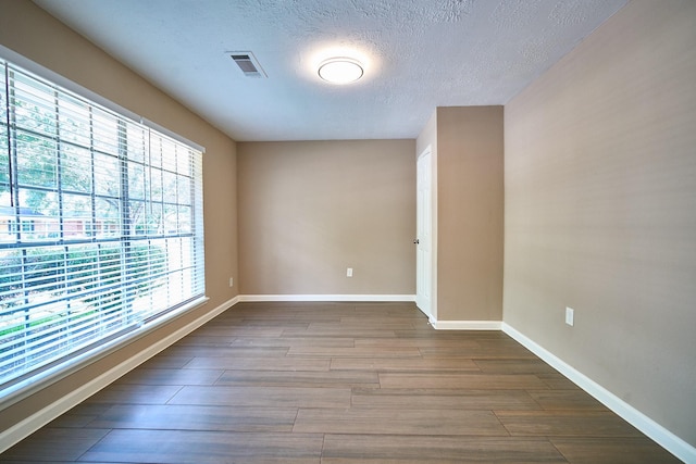 11706 Mclain Blvd, Houston, TX 77071 - empty room with dark wood finished floors, baseboards, and a textured ceiling