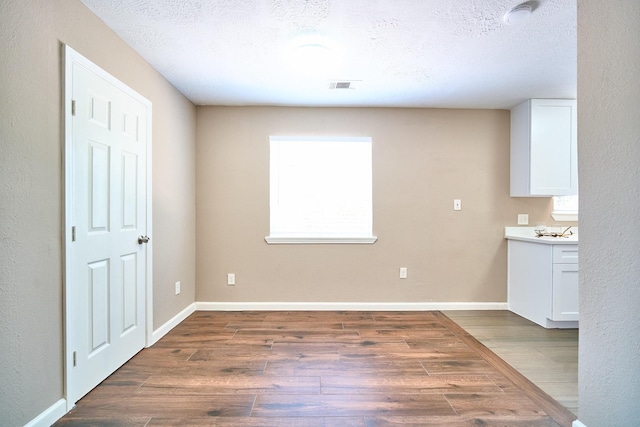 11706 Mclain Blvd, Houston, TX 77071 - unfurnished dining area with wood finished floors, a textured ceiling, and baseboards