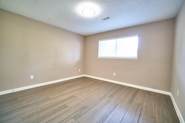 11706 Mclain Blvd, Houston, TX 77071 - unfurnished room with wood finished floors, baseboards, and a textured ceiling