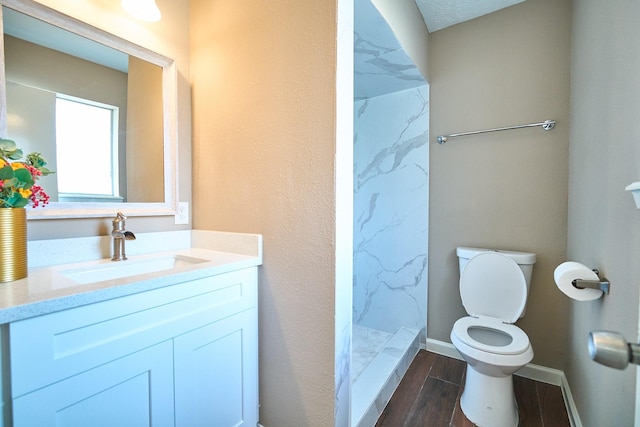11706 Mclain Blvd, Houston, TX 77071 - bathroom with toilet, vanity, a marble finish shower, wood finished floors, and baseboards
