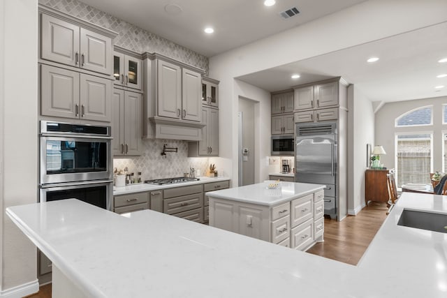 28911 Ally Lynn Way, Katy, TX 77494 - kitchen featuring gray cabinetry, built in appliances, wood finished floors, decorative backsplash, and recessed lighting