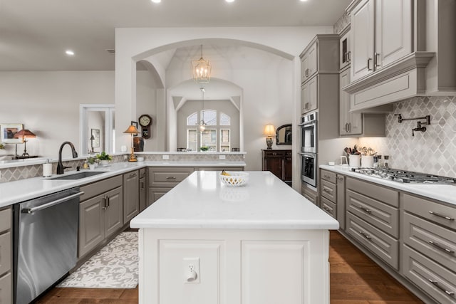28911 Ally Lynn Way, Katy, TX 77494 - kitchen with gray cabinets, appliances with stainless steel finishes, a sink, a center island, and decorative backsplash