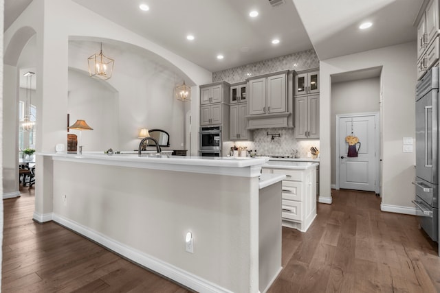 28911 Ally Lynn Way, Katy, TX 77494 - kitchen featuring arched walkways, gray cabinetry, dark wood-type flooring, stainless steel appliances, and light countertops