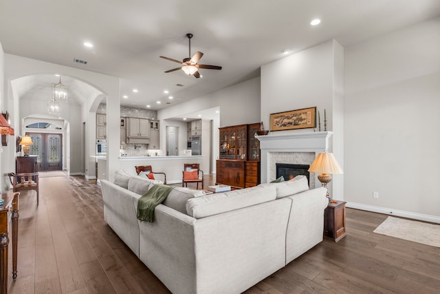 28911 Ally Lynn Way, Katy, TX 77494 - living room with arched walkways, a ceiling fan, dark wood-style floors, a fireplace, and baseboards