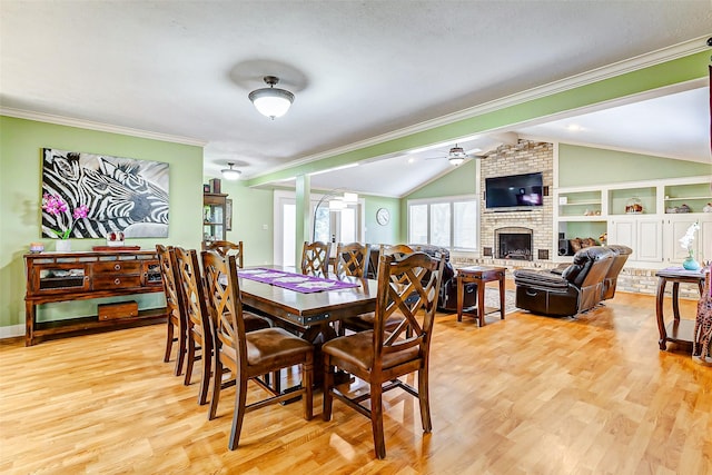 1200 E US Highway 90, Flatonia, TX 78941 - dining room featuring lofted ceiling, a ceiling fan, light wood-style floors, a fireplace, and ornamental molding