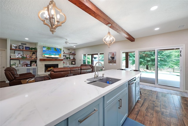 19202 Indigo Lake Dr, Magnolia, TX 77355 - kitchen featuring a sink, a chandelier, a large fireplace, stainless steel dishwasher, and a textured ceiling