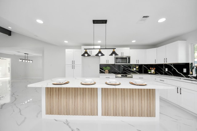 22718 Carter Moir Ln, Katy, TX 77449 - kitchen featuring appliances with stainless steel finishes, a sink, decorative backsplash, light marble finish flooring, and recessed lighting