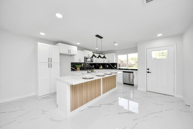 22718 Carter Moir Ln, Katy, TX 77449 - kitchen with appliances with stainless steel finishes, recessed lighting, light marble finish flooring, white cabinetry, and backsplash