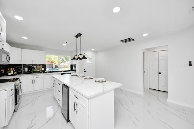 22718 Carter Moir Ln, Katy, TX 77449 - kitchen featuring stainless steel appliances, recessed lighting, light marble finish flooring, a kitchen island, and baseboards