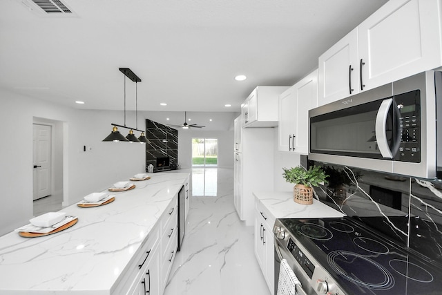 22718 Carter Moir Ln, Katy, TX 77449 - kitchen featuring appliances with stainless steel finishes, light marble finish flooring, white cabinetry, light stone counters, and recessed lighting