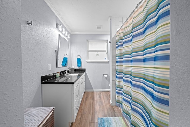 3010 Helberg Rd, Houston, TX 77092 - bathroom with a textured wall, vanity, crown molding, wood finished floors, and baseboards