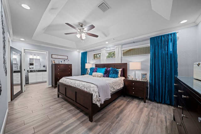 3010 Helberg Rd, Houston, TX 77092 - bedroom with a tray ceiling, light wood-style floors, connected bathroom, recessed lighting, and ceiling fan
