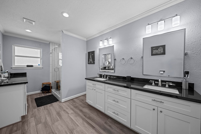 3010 Helberg Rd, Houston, TX 77092 - full bath featuring crown molding, a textured ceiling, double vanity, a shower stall, and wood finished floors