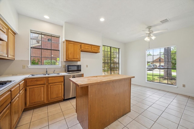 14507 Sycamore Lake Rd, Houston, TX 77062 - kitchen with appliances with stainless steel finishes, a sink, light tile patterned floors, a center island, and recessed lighting