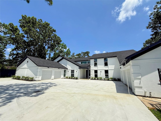 12564 Memorial Dr, Houston, TX 77024 - modern farmhouse style home featuring stucco siding, a garage, concrete driveway, and roof with shingles