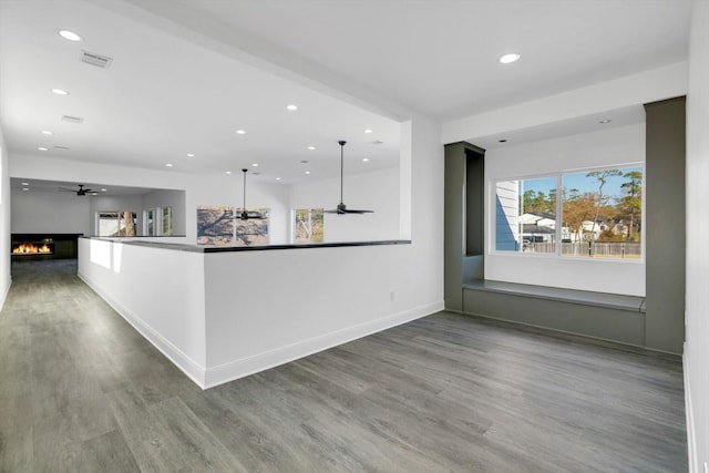 12564 Memorial Dr, Houston, TX 77024 - kitchen featuring wood finished floors, recessed lighting, ceiling fan, open floor plan, and a warm lit fireplace