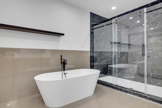 12564 Memorial Dr, Houston, TX 77024 - full bathroom featuring a soaking tub, tile walls, a marble finish shower, and recessed lighting
