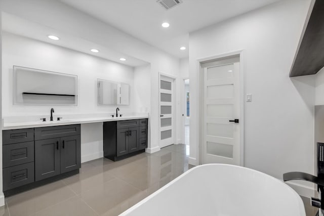 12564 Memorial Dr, Houston, TX 77024 - bathroom featuring a freestanding bath, recessed lighting, double vanity, and tile patterned floors