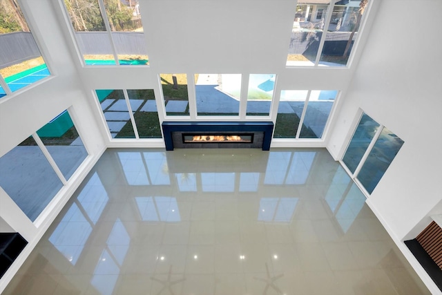 12564 Memorial Dr, Houston, TX 77024 - living area with a high ceiling, a glass covered fireplace, and tile patterned flooring