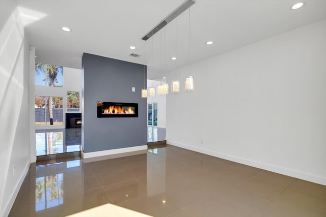 12564 Memorial Dr, Houston, TX 77024 - unfurnished living room featuring a glass covered fireplace, recessed lighting, and tile patterned floors