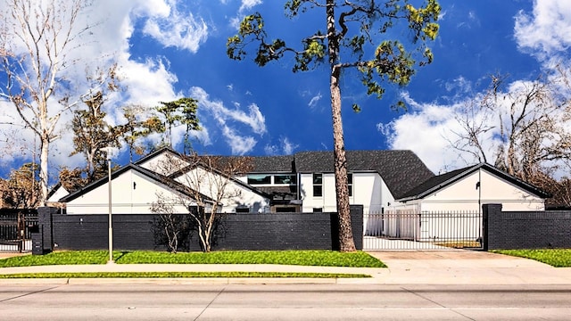 12564 Memorial Dr, Houston, TX 77024 - view of front facade with a fenced front yard, concrete driveway, and a gate