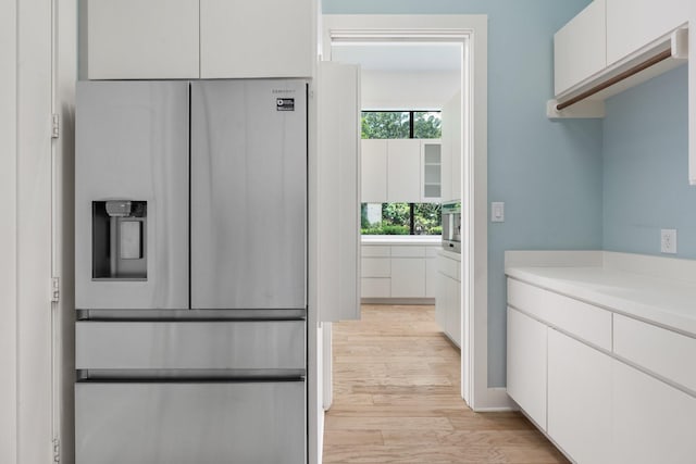 16827 Falcon Sound Dr, Montgomery, TX 77356 - kitchen with stainless steel refrigerator with ice dispenser, white cabinets, light wood-style floors, and light countertops