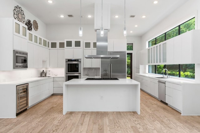 16827 Falcon Sound Dr, Montgomery, TX 77356 - kitchen with beverage cooler, modern cabinets, stainless steel appliances, island range hood, and white cabinetry