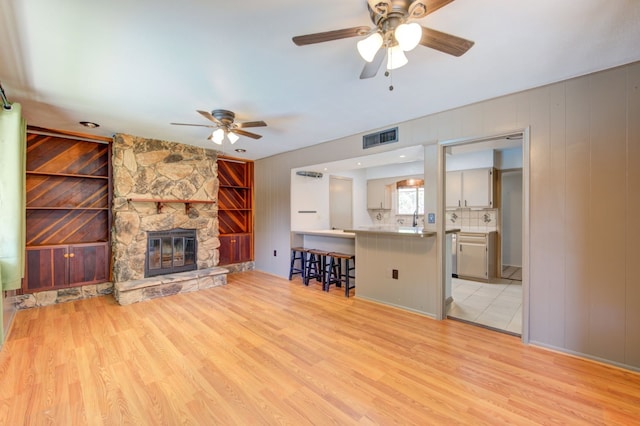 1402 Beachcomber Ln, Houston, TX 77062 - unfurnished living room featuring a ceiling fan, light wood-style flooring, a fireplace, and a sink