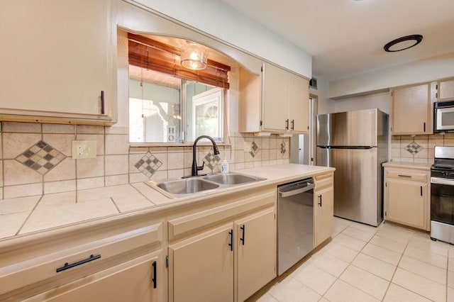 1402 Beachcomber Ln, Houston, TX 77062 - kitchen with stainless steel appliances, a sink, tasteful backsplash, light tile patterned floors, and cream cabinets