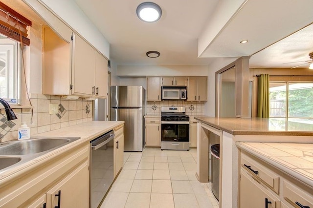1402 Beachcomber Ln, Houston, TX 77062 - kitchen with appliances with stainless steel finishes, a sink, decorative backsplash, light tile patterned floors, and light countertops