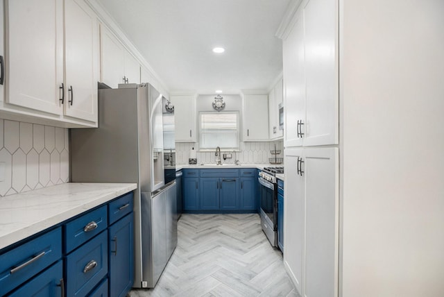 5720 Fraser Ave, Galveston, TX 77551 - kitchen with appliances with stainless steel finishes, blue cabinets, white cabinetry, decorative backsplash, and recessed lighting