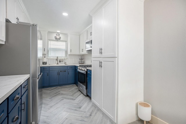 5720 Fraser Ave, Galveston, TX 77551 - kitchen featuring stainless steel appliances, blue cabinets, a sink, white cabinets, and recessed lighting