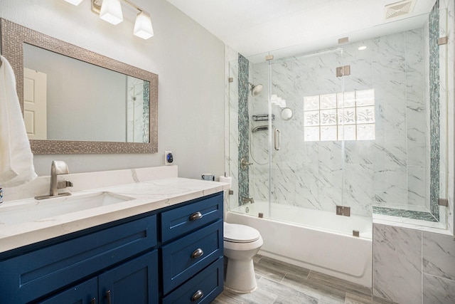 5720 Fraser Ave, Galveston, TX 77551 - full bath featuring toilet, vanity, wood finished floors, and enclosed tub / shower combo
