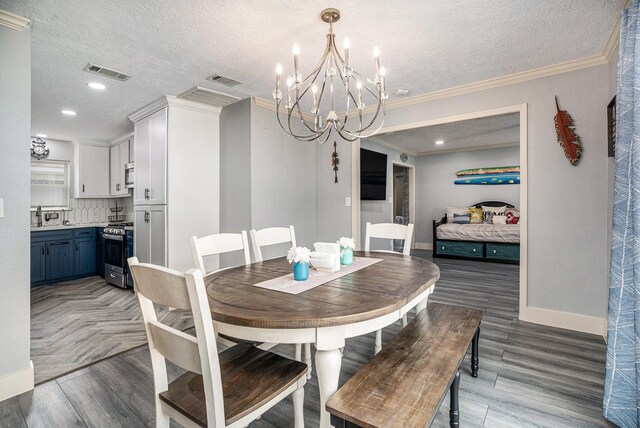 5720 Fraser Ave, Galveston, TX 77551 - dining room with a chandelier, baseboards, a textured ceiling, light wood-style floors, and ornamental molding