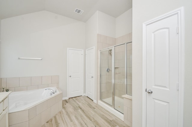 426 Sunny River Ln, Richmond, TX 77406 - bathroom with a stall shower, a garden tub, vaulted ceiling, wood finished floors, and vanity