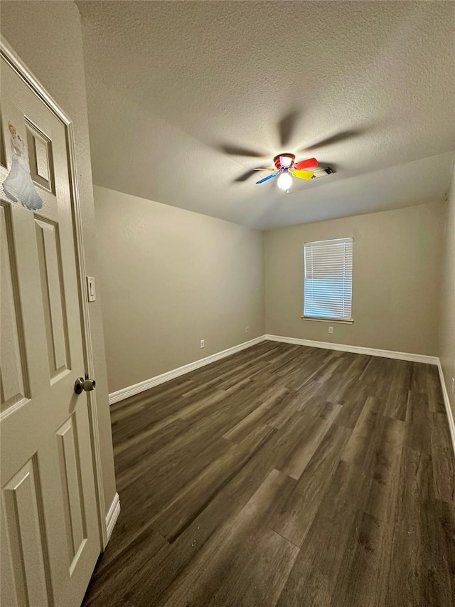15318 Griggs Point Ln, Sugar Land, TX 77498 - empty room featuring dark wood-style flooring, a textured ceiling, baseboards, and a ceiling fan
